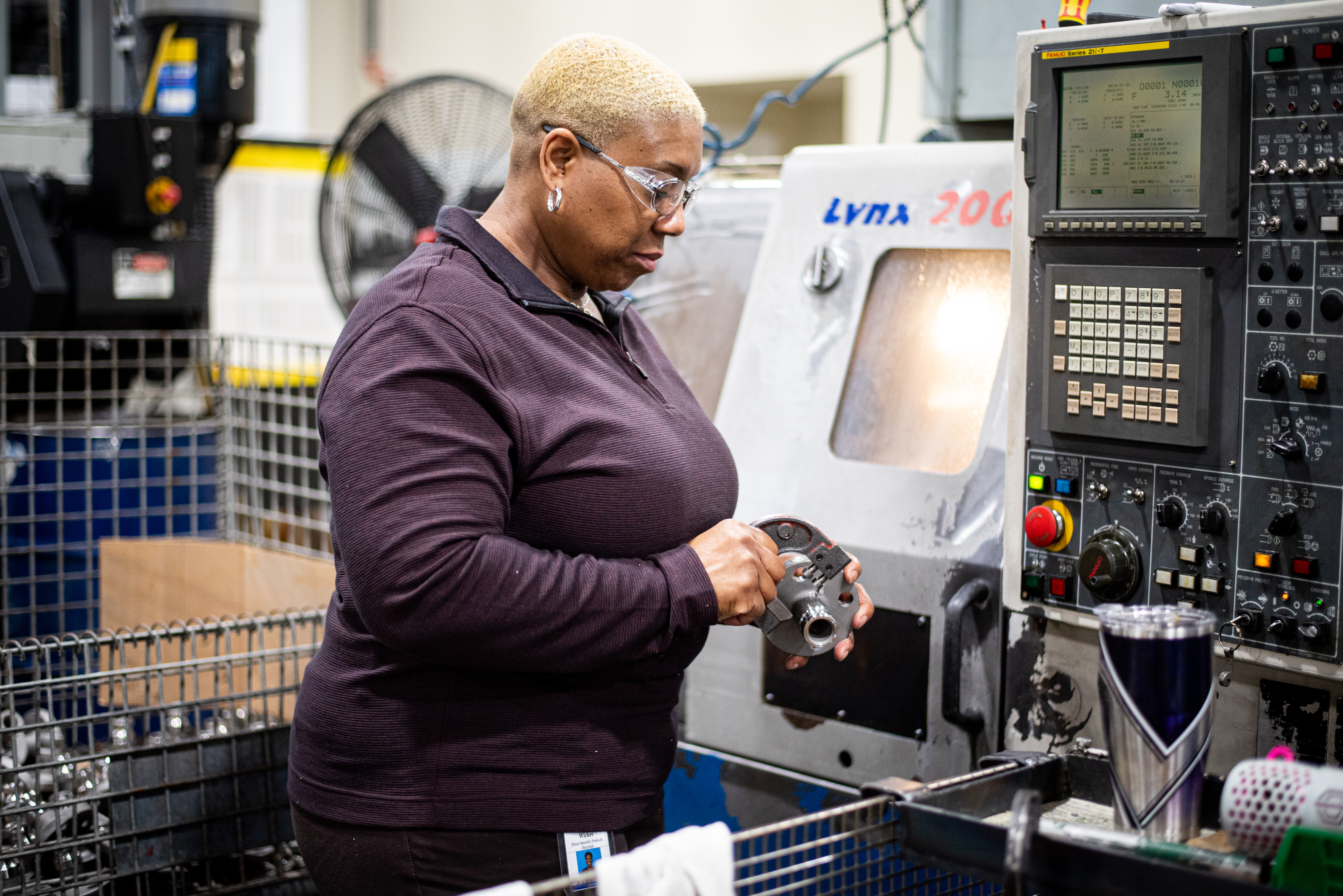 Machinist measuring product during quality assurance inspection.